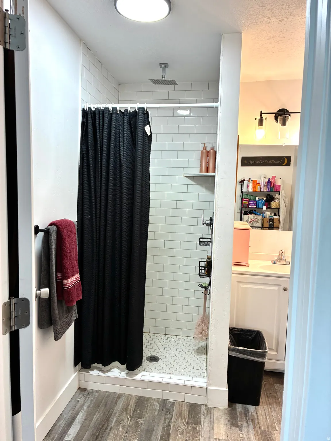 Bathroom with vanity, wood finished floors, a shower stall, and a textured ceiling