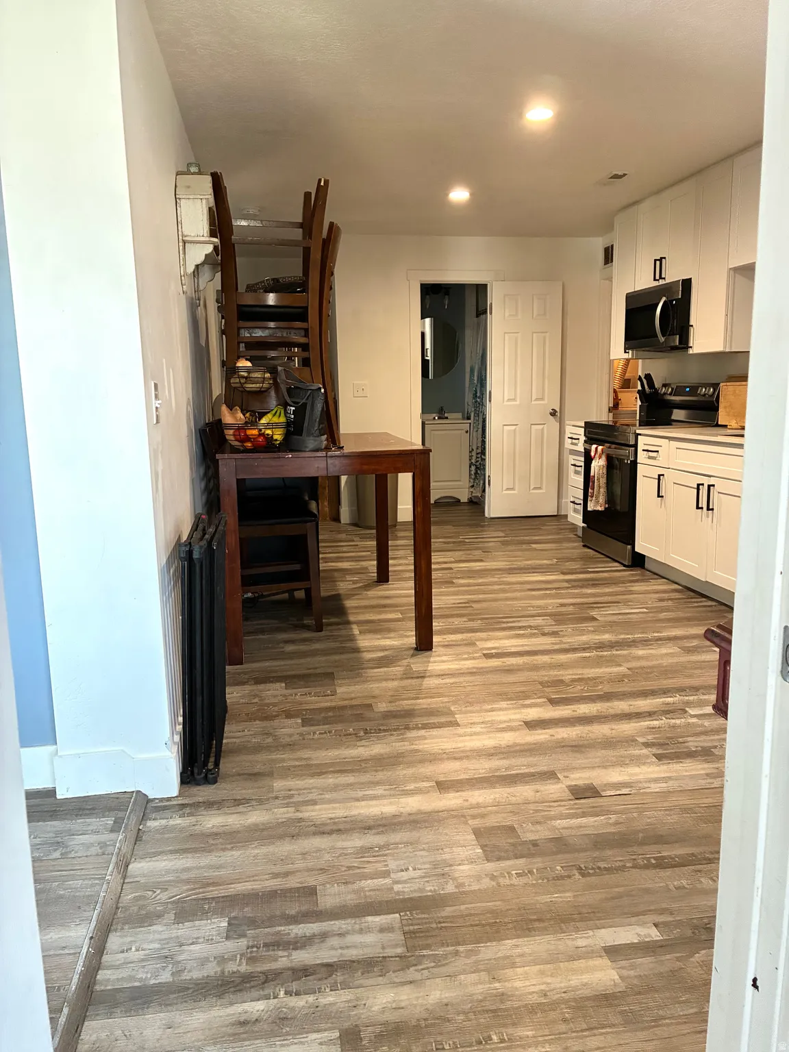 Kitchen with stainless steel appliances, white cabinetry.