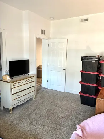 Bedroom featuring carpet and baseboards