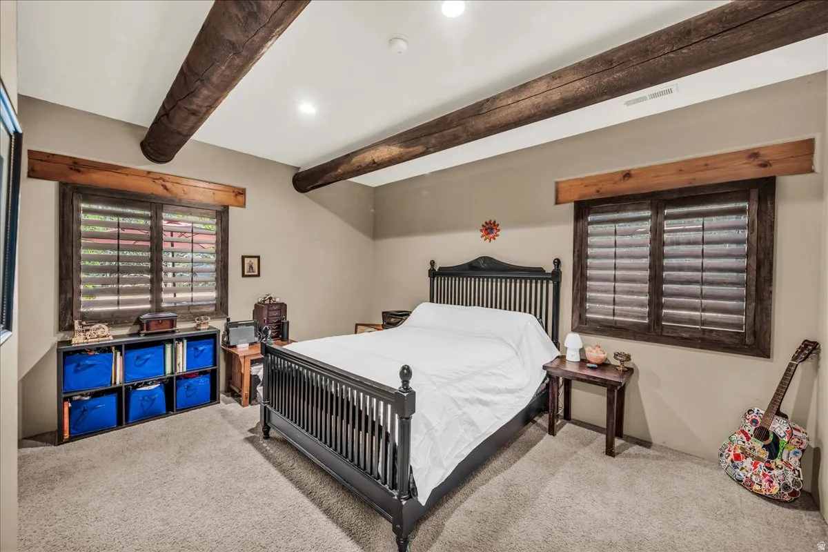 Bedroom featuring carpet, beamed ceiling, and recessed lighting