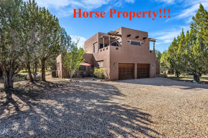 Southwestern-style residence featuring a stucco exterior and a gravel driveway