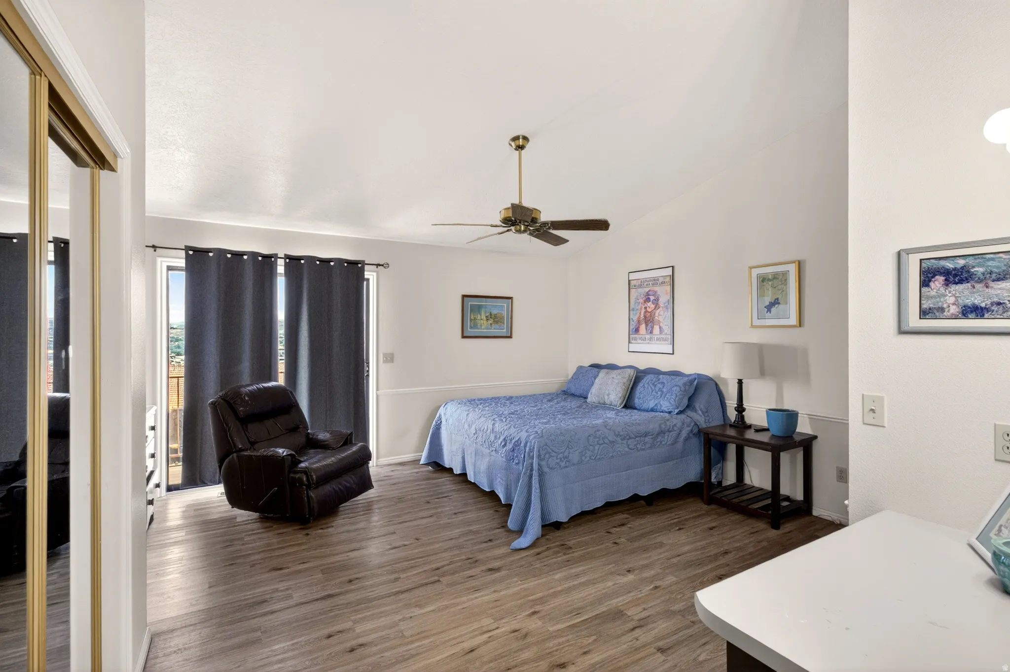 Bedroom with access to exterior, dark wood-style flooring, vaulted ceiling, and ceiling fan