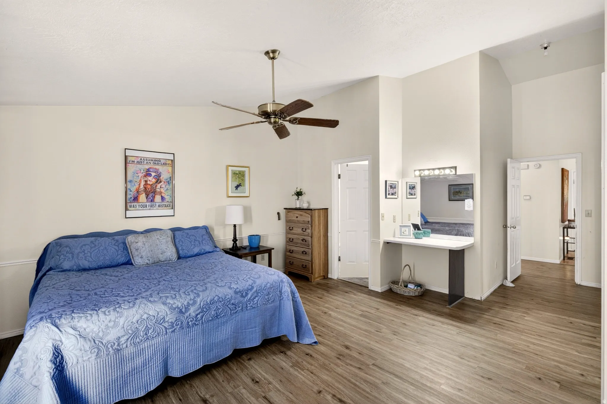 Bedroom with vaulted ceiling, wood finished floors, and ceiling fan
