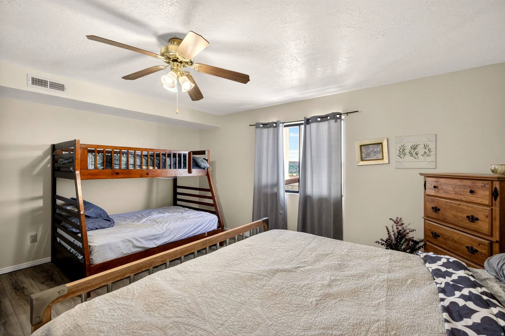 Bedroom featuring a textured ceiling, ceiling fan, and wood finished floors