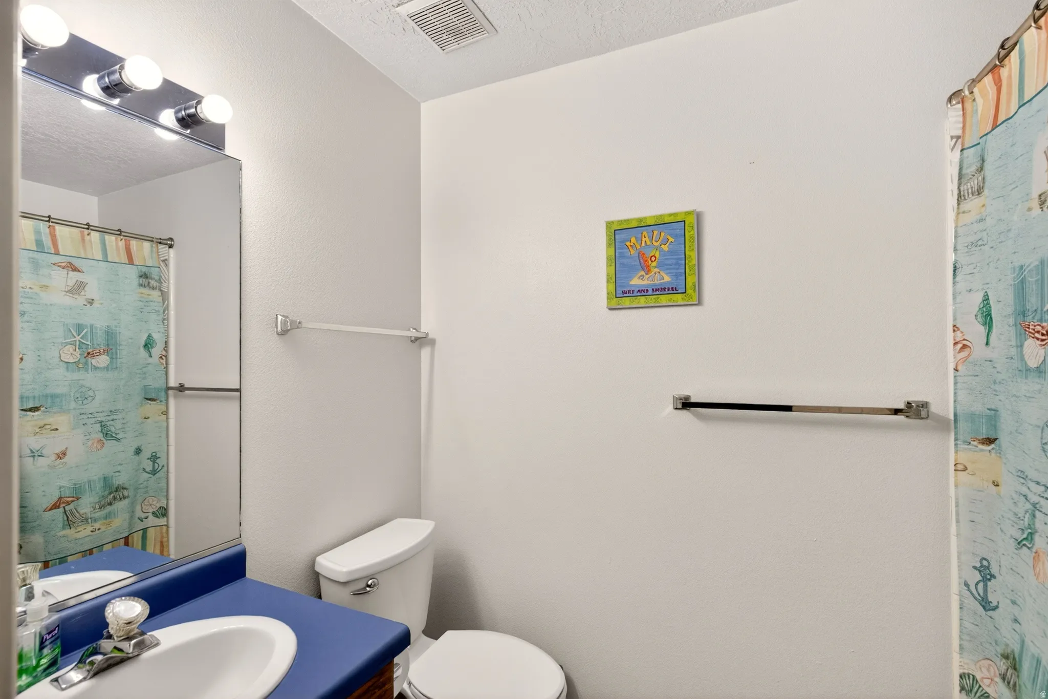 Bathroom featuring a shower with curtain, vanity, and a textured ceiling