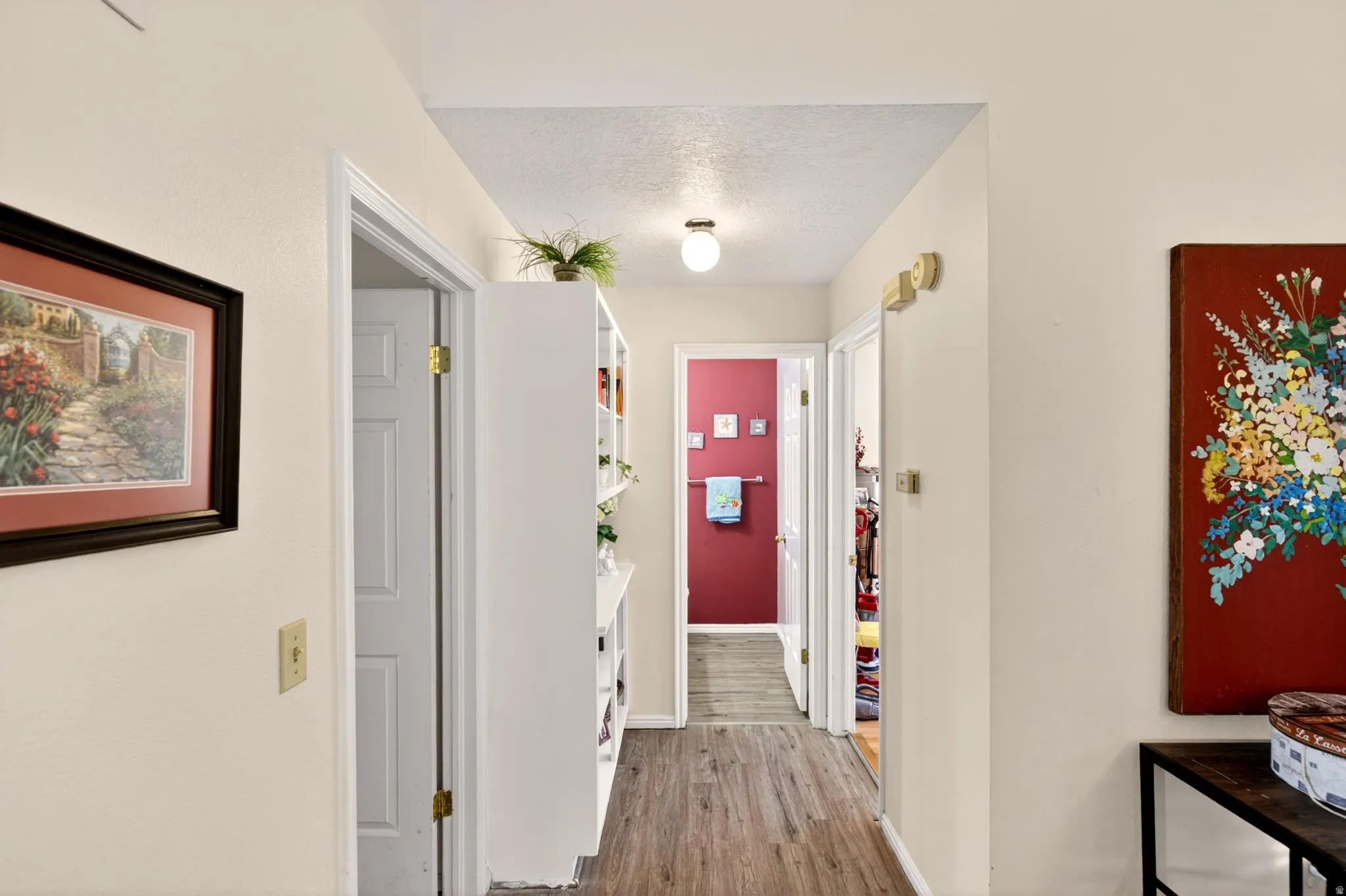 Hall featuring a textured ceiling and light wood-type flooring