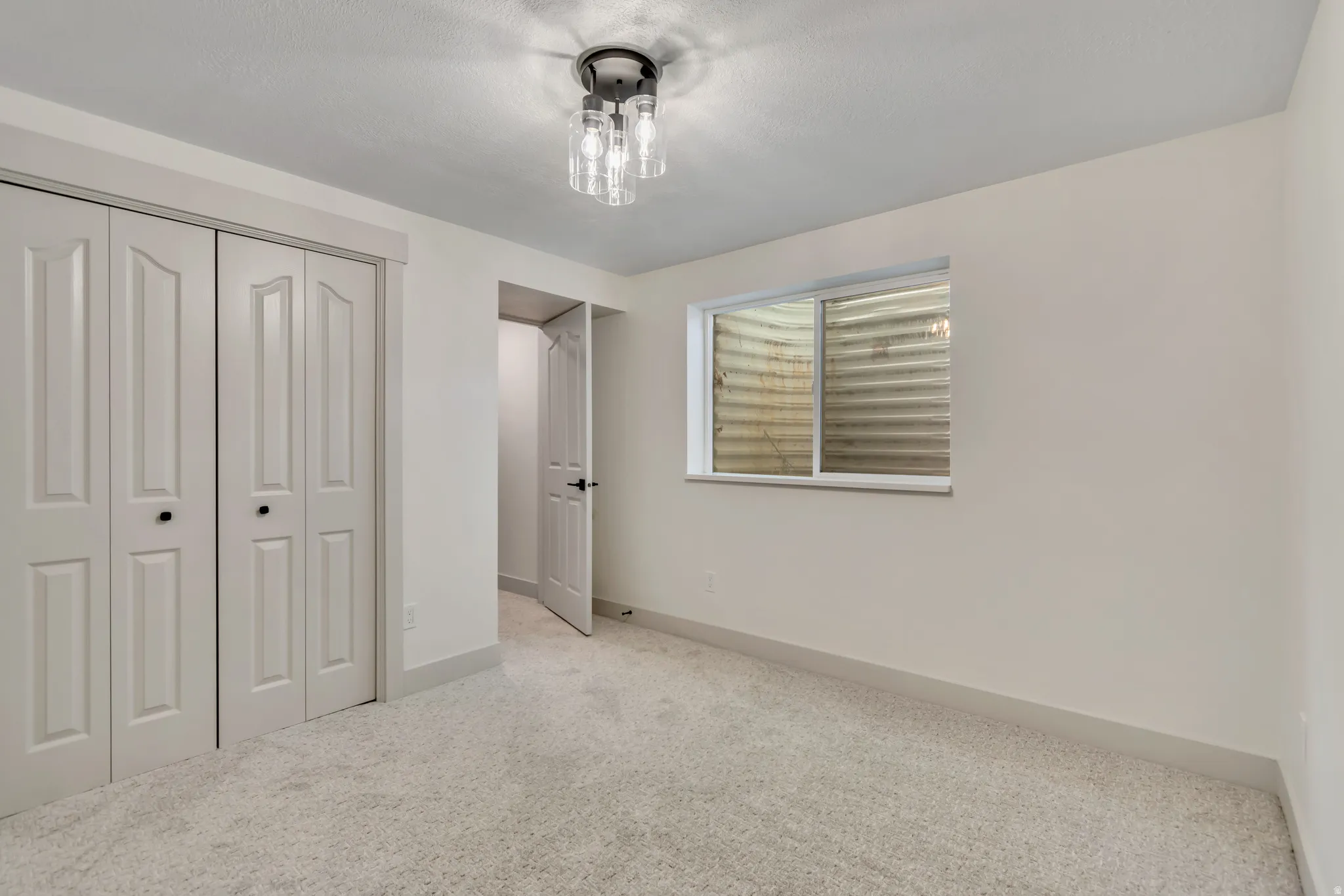 Unfurnished bedroom featuring light colored carpet and a closet