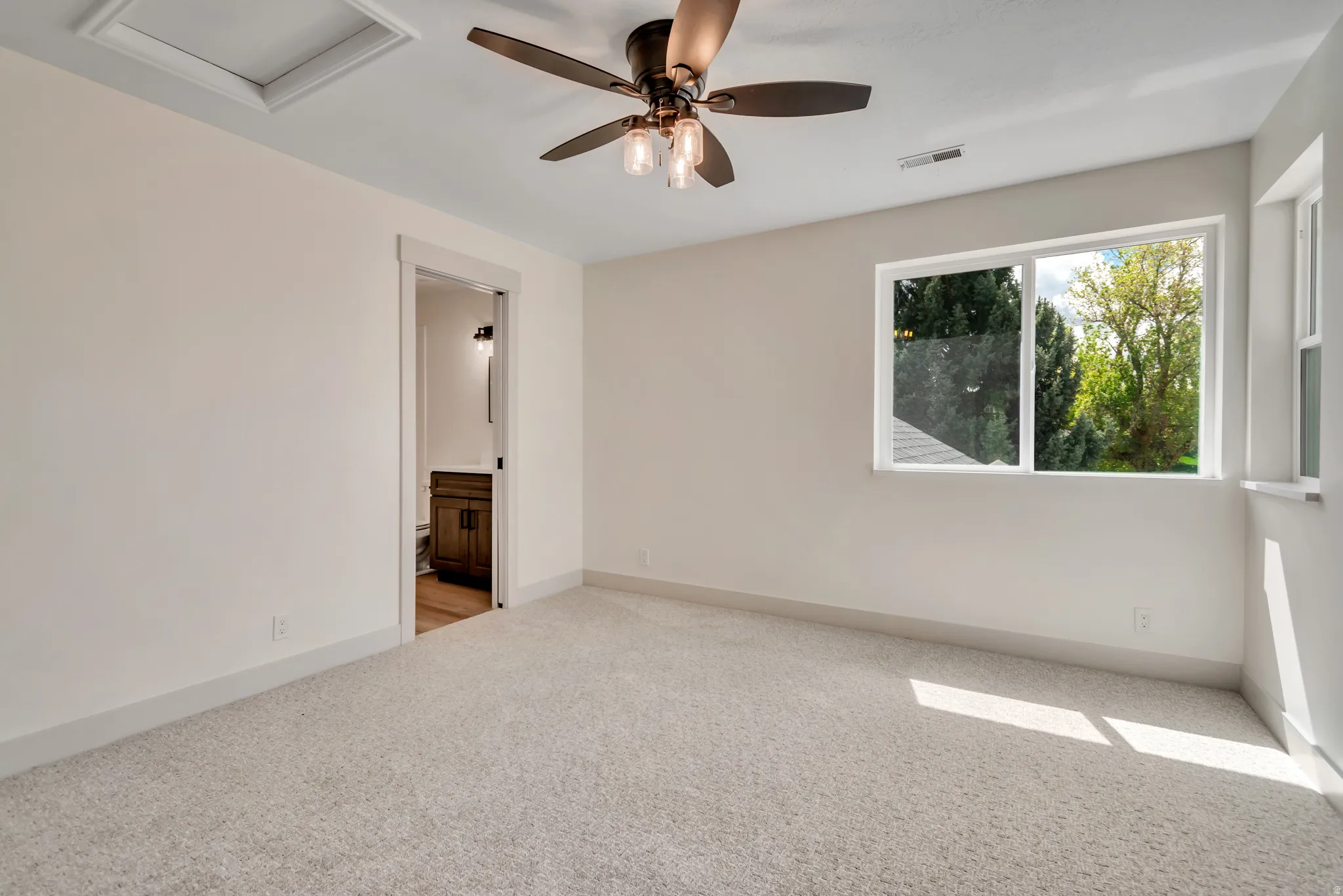 Empty room featuring light carpet and ceiling fan