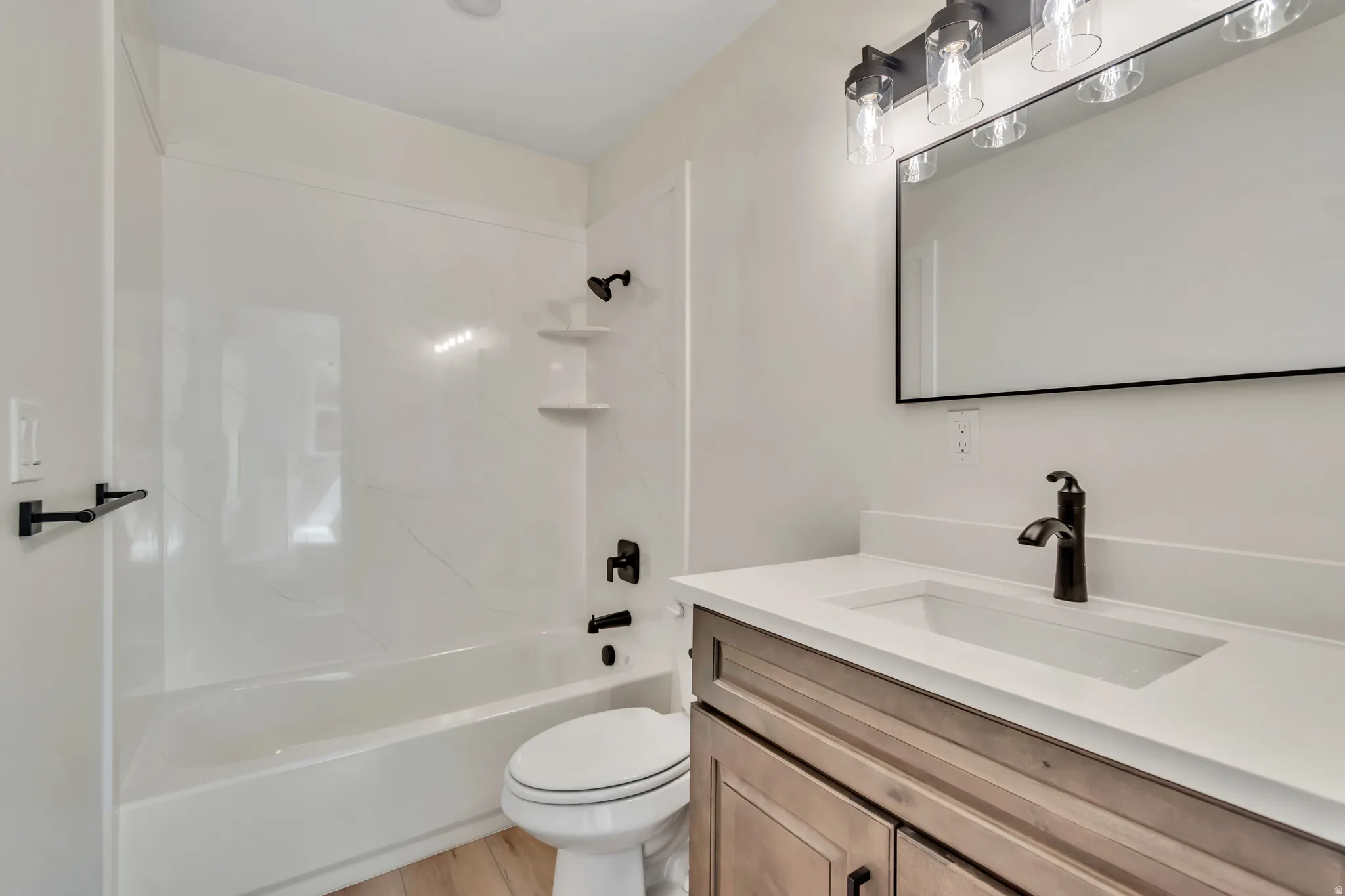 Full bathroom featuring vanity, bathing tub / shower combination, and light wood-type flooring