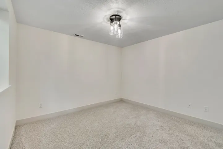 Carpeted spare room with baseboards and a textured ceiling
