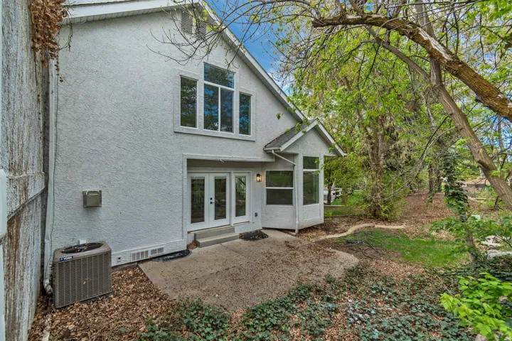 Back of property with stucco siding, french doors, and a sunroom
