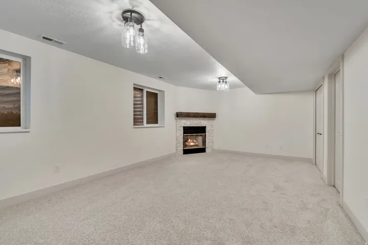 Unfurnished living room with light colored carpet and a fireplace