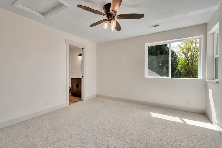 Empty room featuring light carpet and ceiling fan