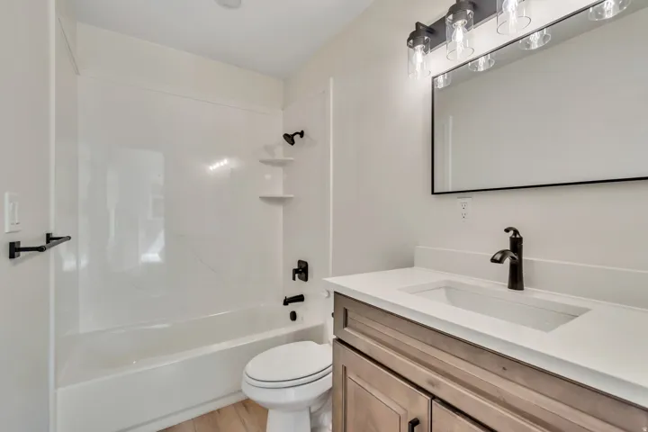 Full bathroom featuring vanity, bathing tub / shower combination, and light wood-type flooring