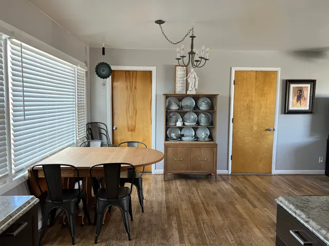 Dining space with dark wood finished floors and a chandelier