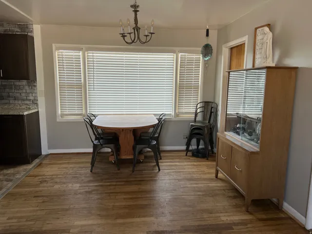 Dining area with dark wood-style floors and hanging lights