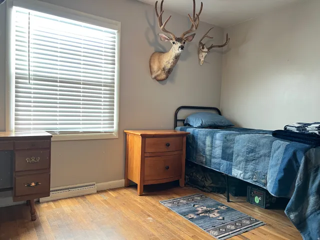 Bedroom with light wood-type flooring and a baseboard radiator