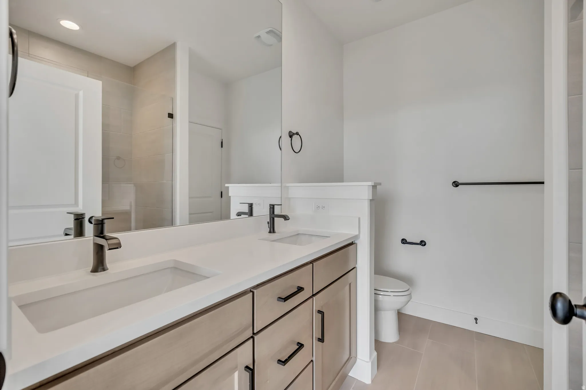 Bathroom with double vanity and light tile patterned flooring