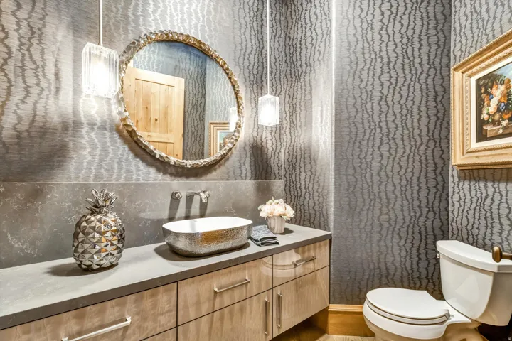 Half bath featuring wallpapered walls and vanity