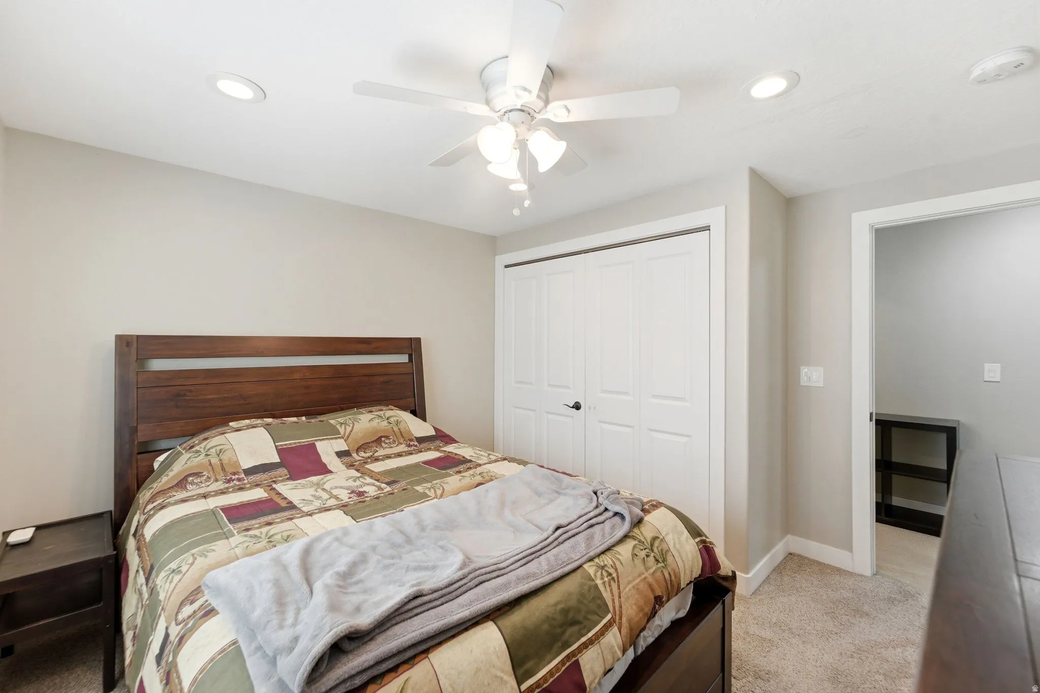Bedroom featuring light colored carpet, a closet, a ceiling fan, and recessed lighting