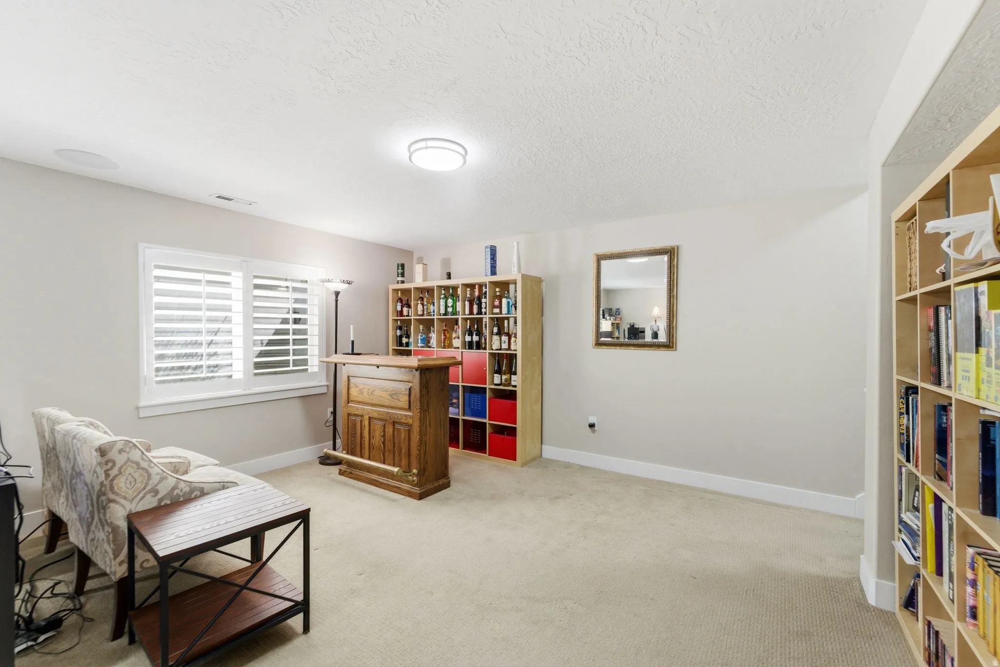 Sitting room with light carpet and a textured ceiling