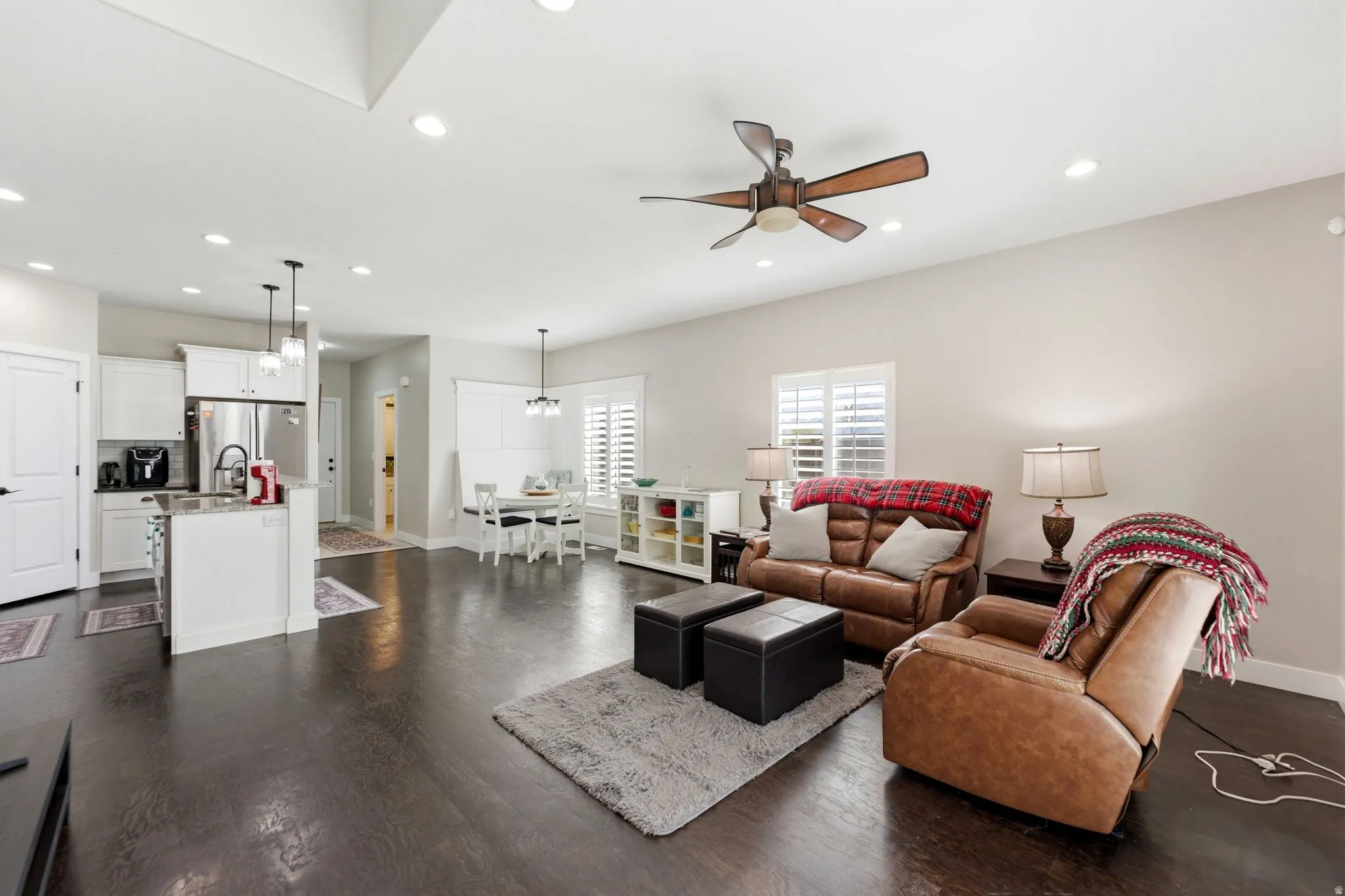 Living area featuring dark wood-style flooring, recessed lighting, and a ceiling fan