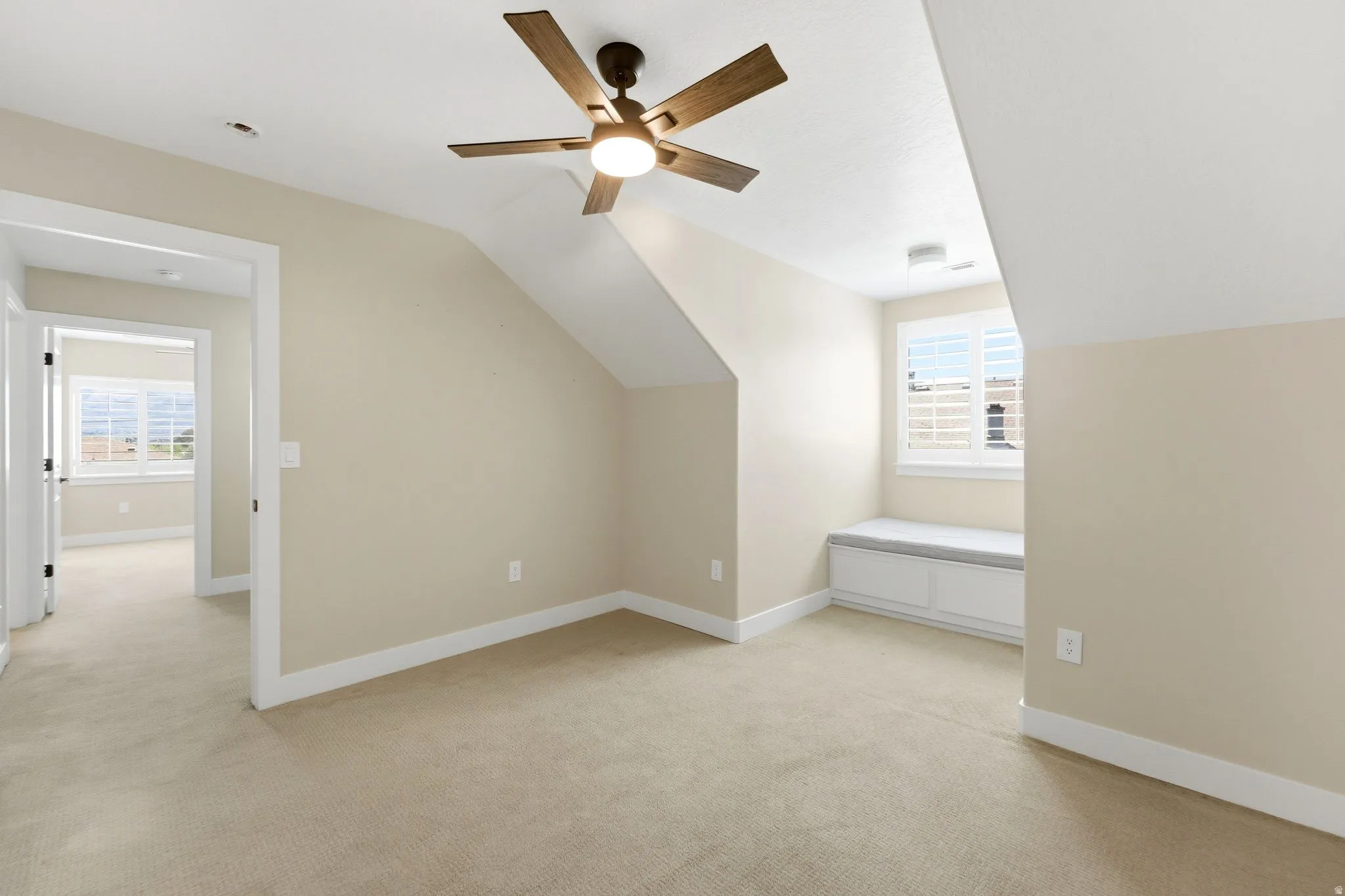 Bonus room featuring lofted ceiling, light colored carpet, and a ceiling fan