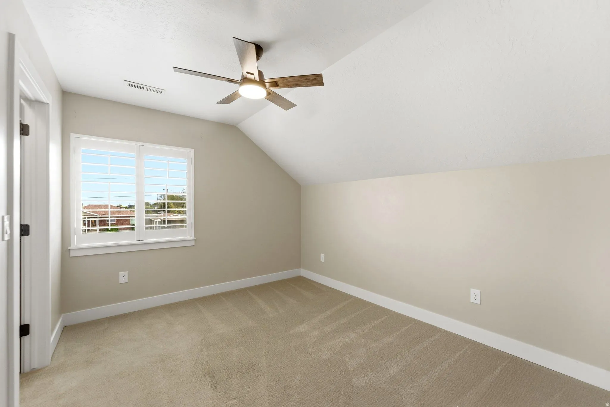 Bonus room featuring vaulted ceiling, ceiling fan, and light carpet
