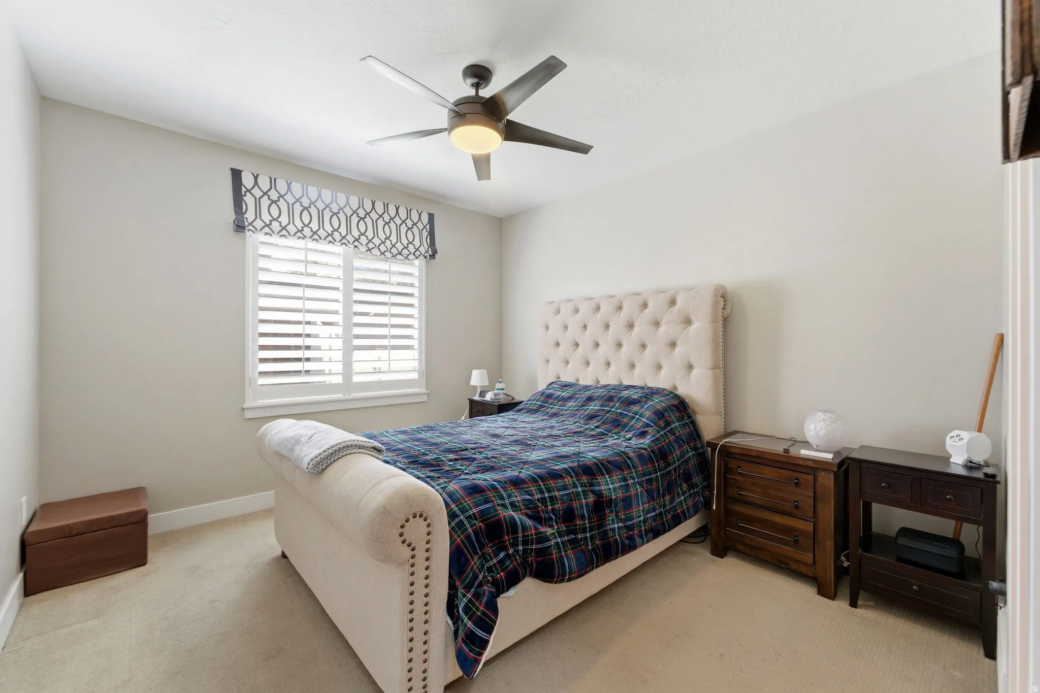 Bedroom with light colored carpet and ceiling fan