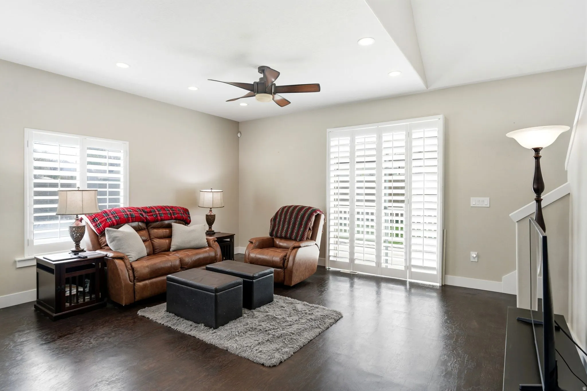 Living room with a ceiling fan, recessed lighting, and dark wood-type flooring