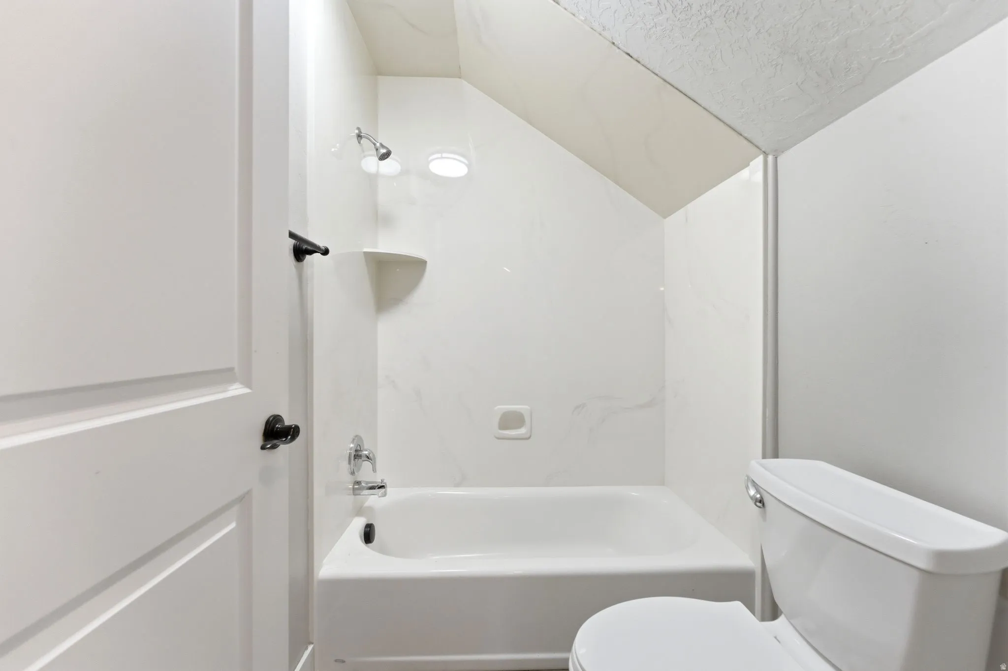 Full bath with lofted ceiling and bathtub / shower combination