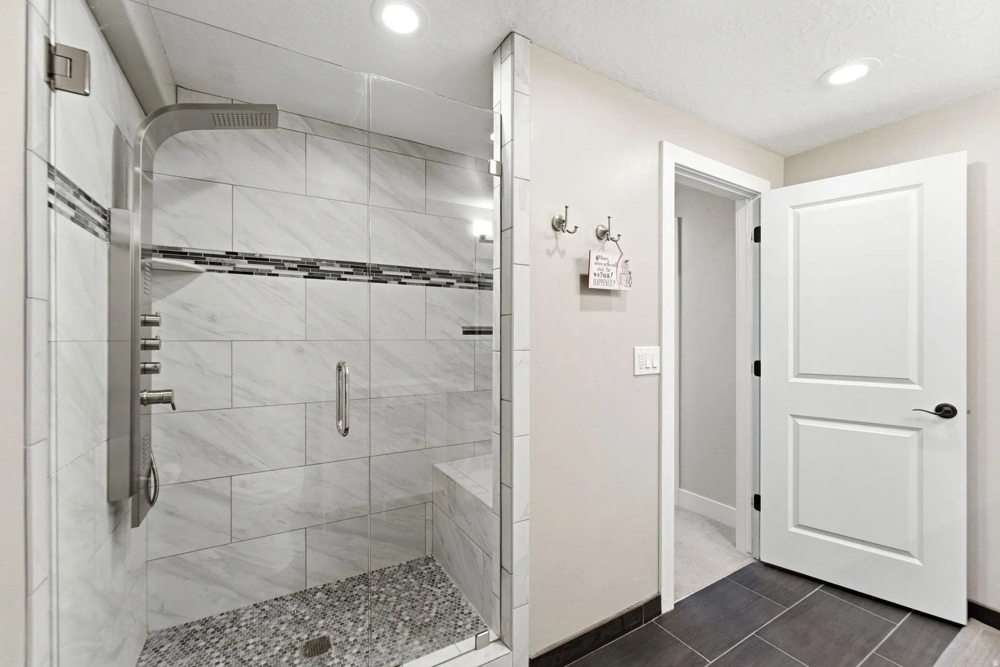 Bathroom with a shower stall, recessed lighting, and dark tile patterned floors