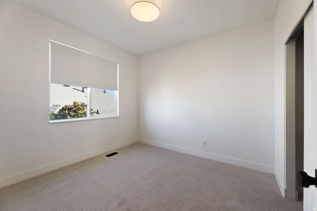 Spare room with light carpet and baseboards