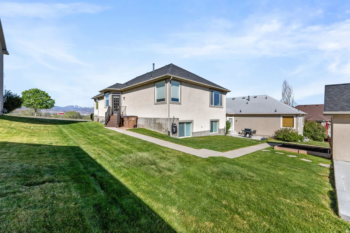 Rear view of property with a yard and stucco siding