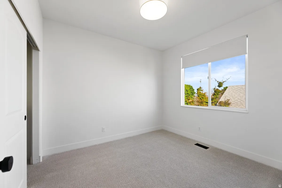 Unfurnished bedroom featuring light colored carpet and a closet