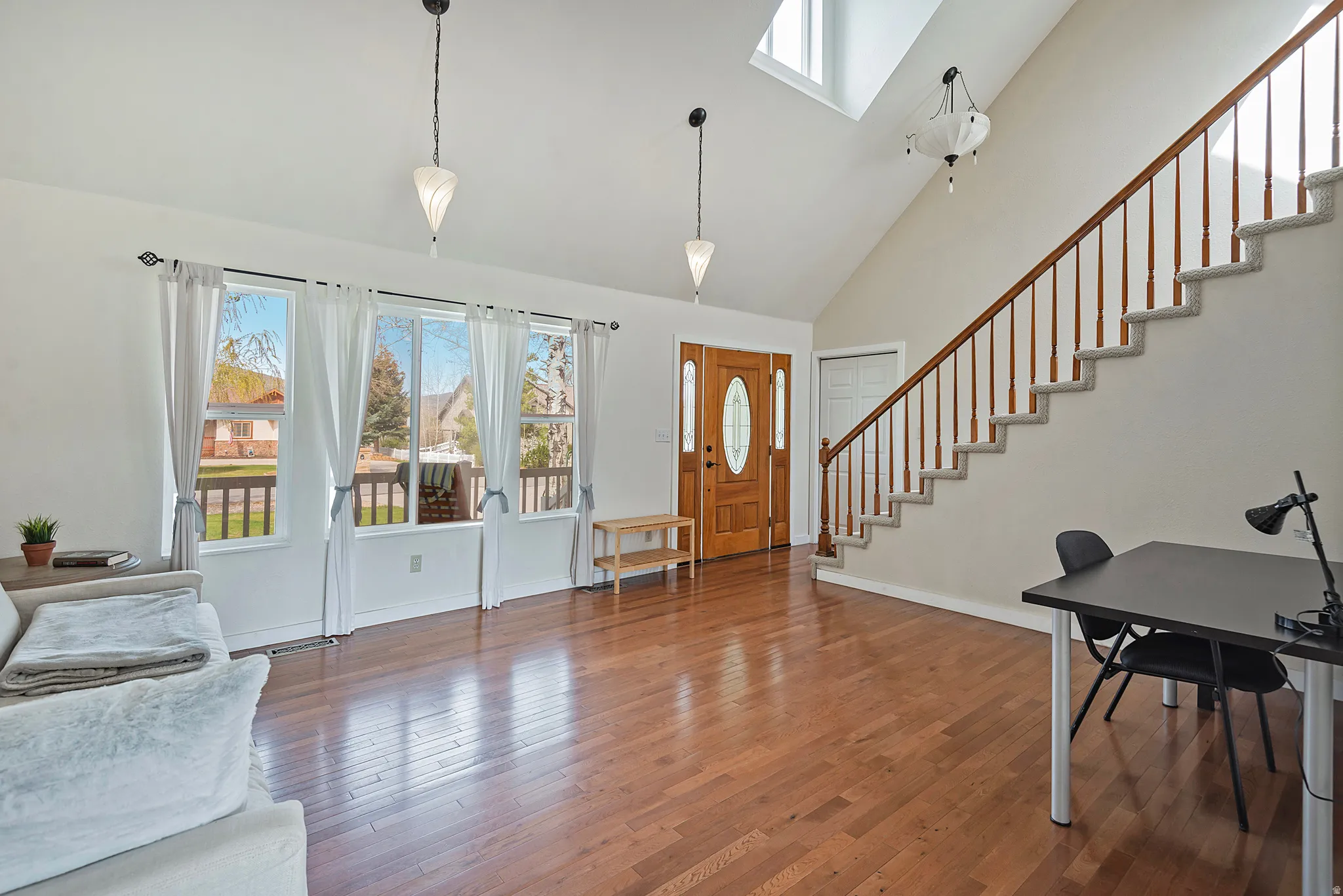 Entrance foyer with plenty of natural light, a skylight, dark wood finished floors, and lofted ceiling