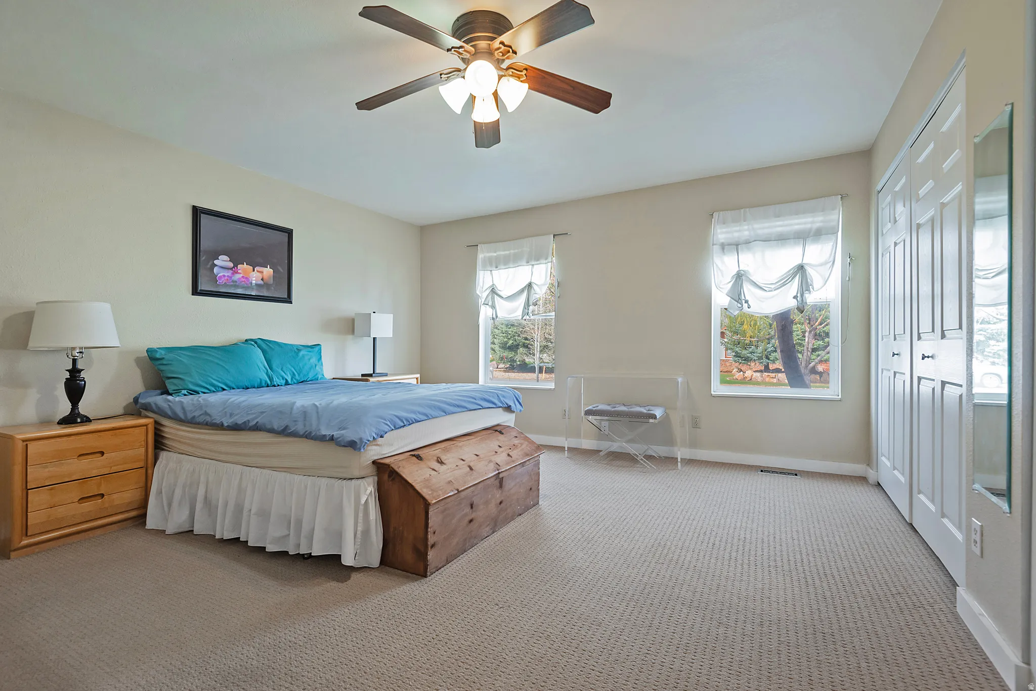 Bedroom featuring a closet, light carpet, and ceiling fan