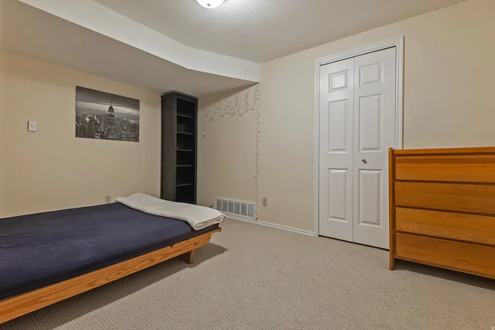 Bedroom featuring light colored carpet and a closet