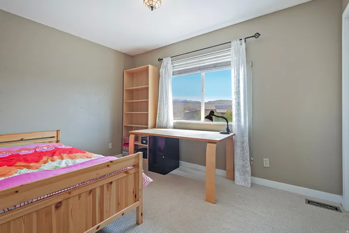 Bedroom featuring light colored carpet and a mountain view