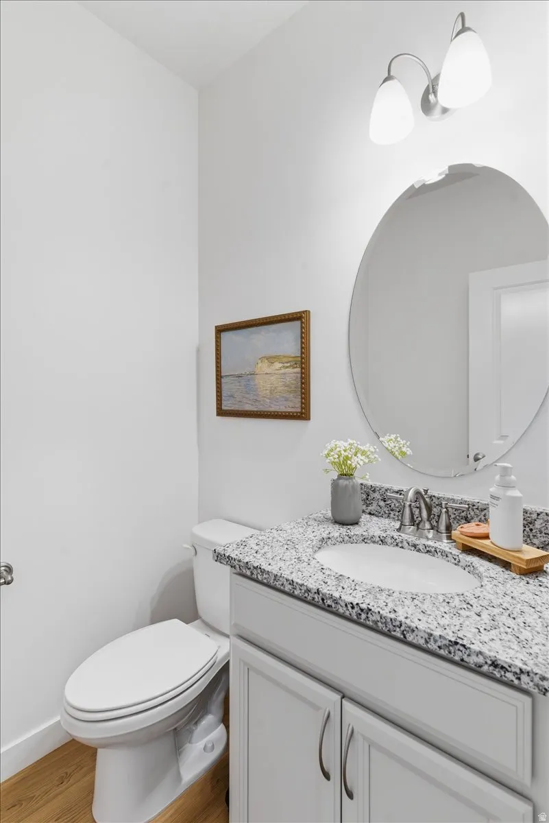 Half bath with vanity and light wood-style floors