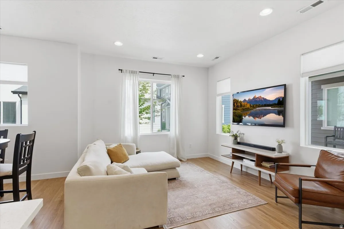 Living room with light wood-style flooring and recessed lighting
