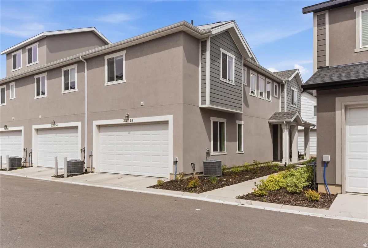 View of side of home with an attached garage and stucco siding