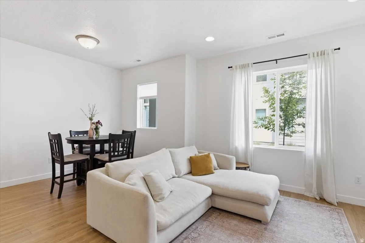Living area with light wood-style flooring, healthy amount of natural light, and recessed lighting