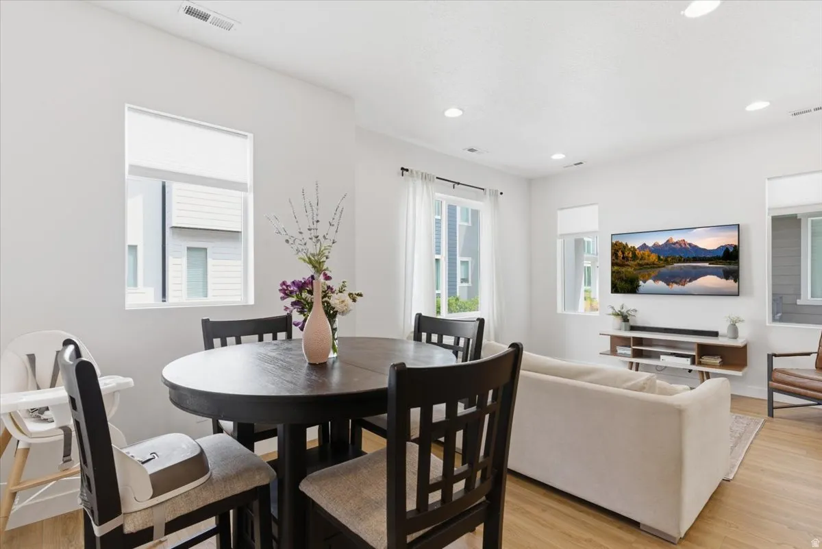 Dining space with light wood finished floors and recessed lighting