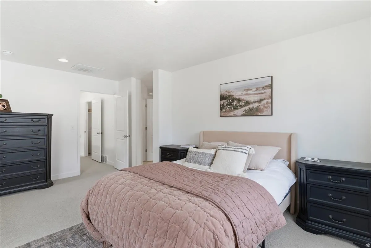 Bedroom with light colored carpet and baseboards