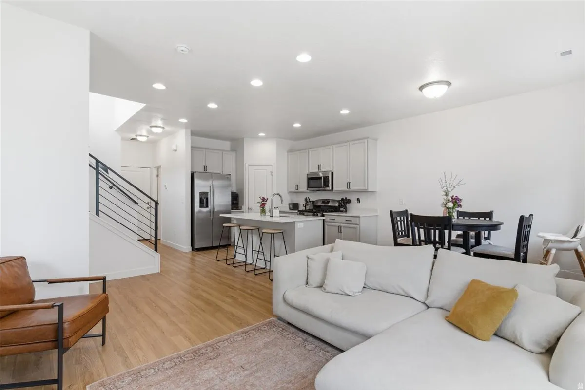 Living room with light wood finished floors and recessed lighting
