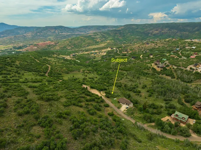 Aerial view of property and surrounding area featuring property parcel outlined and mountains