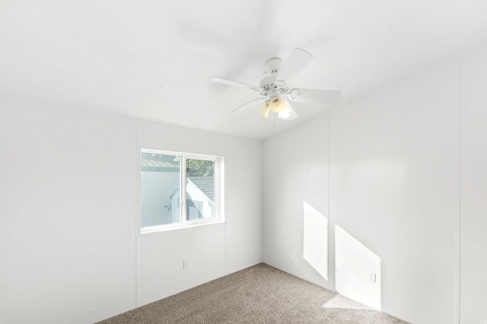 Spare room with ceiling fan and carpet
