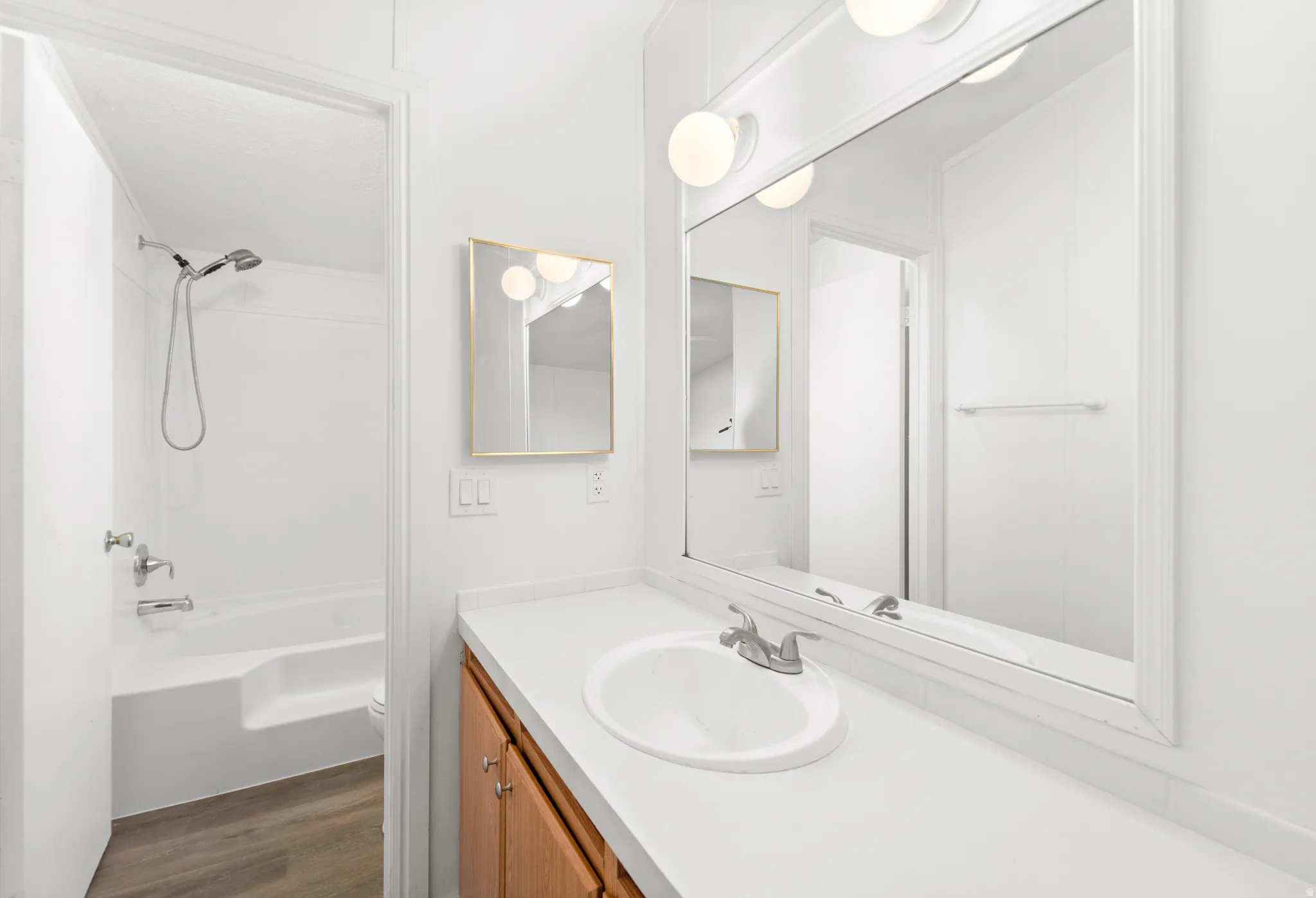 Full bathroom featuring vanity, dark wood-style floors, and washtub / shower combination