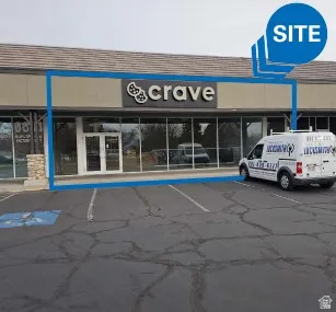 View of commercial property with uncovered parking